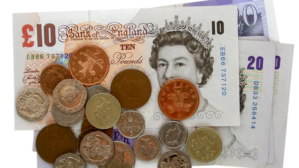 A pile of pound coins on top of notes.